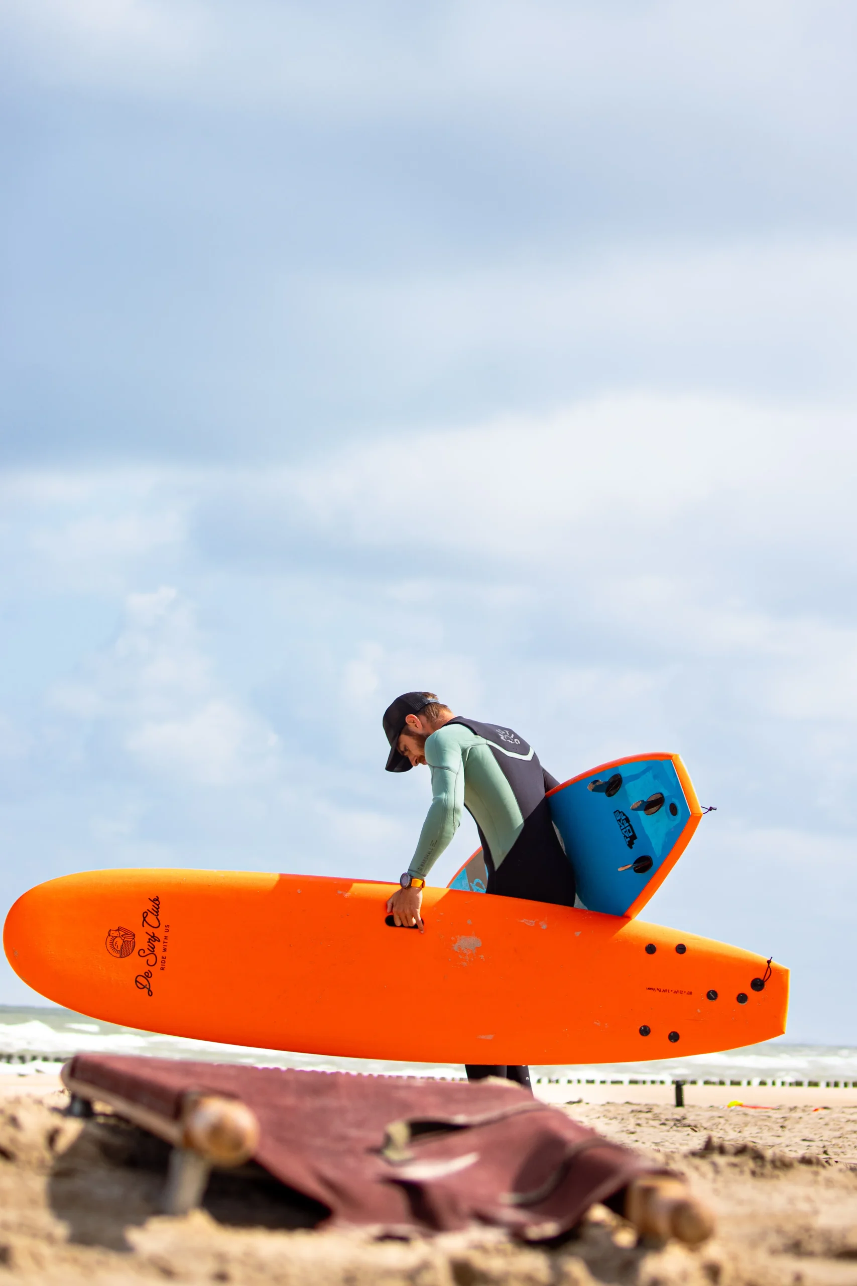 Man tilt twee surfplanken op het strand